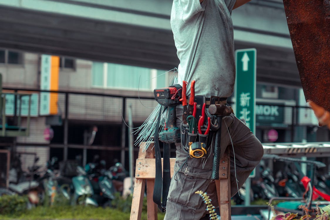 Vakman op ladder bij dakgoot reparatie aan een Tilburgse woning