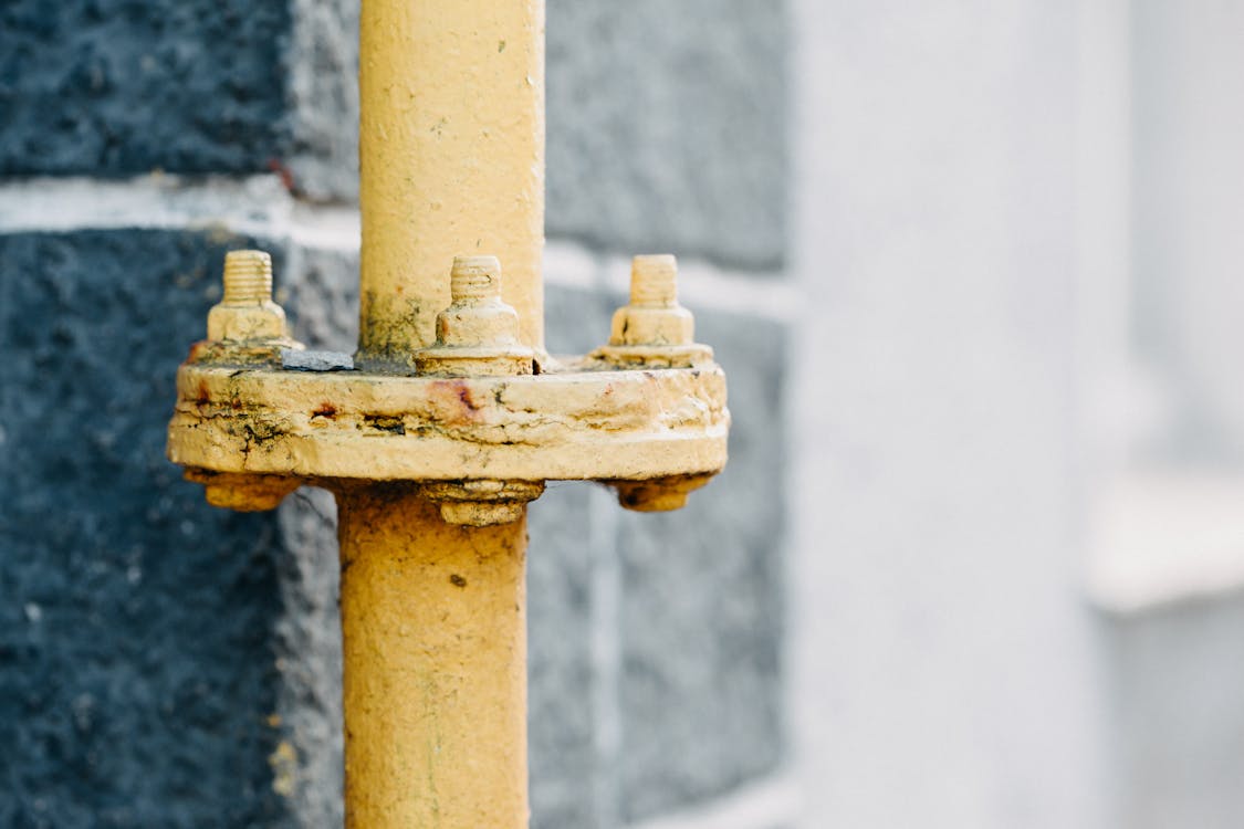 Close-up van een gele gasleiding met afsluiter