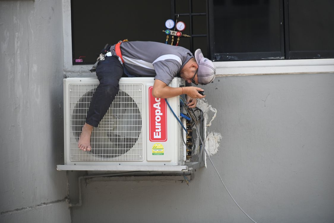 Technicus werkt aan de buitenunit van een warmtepomp