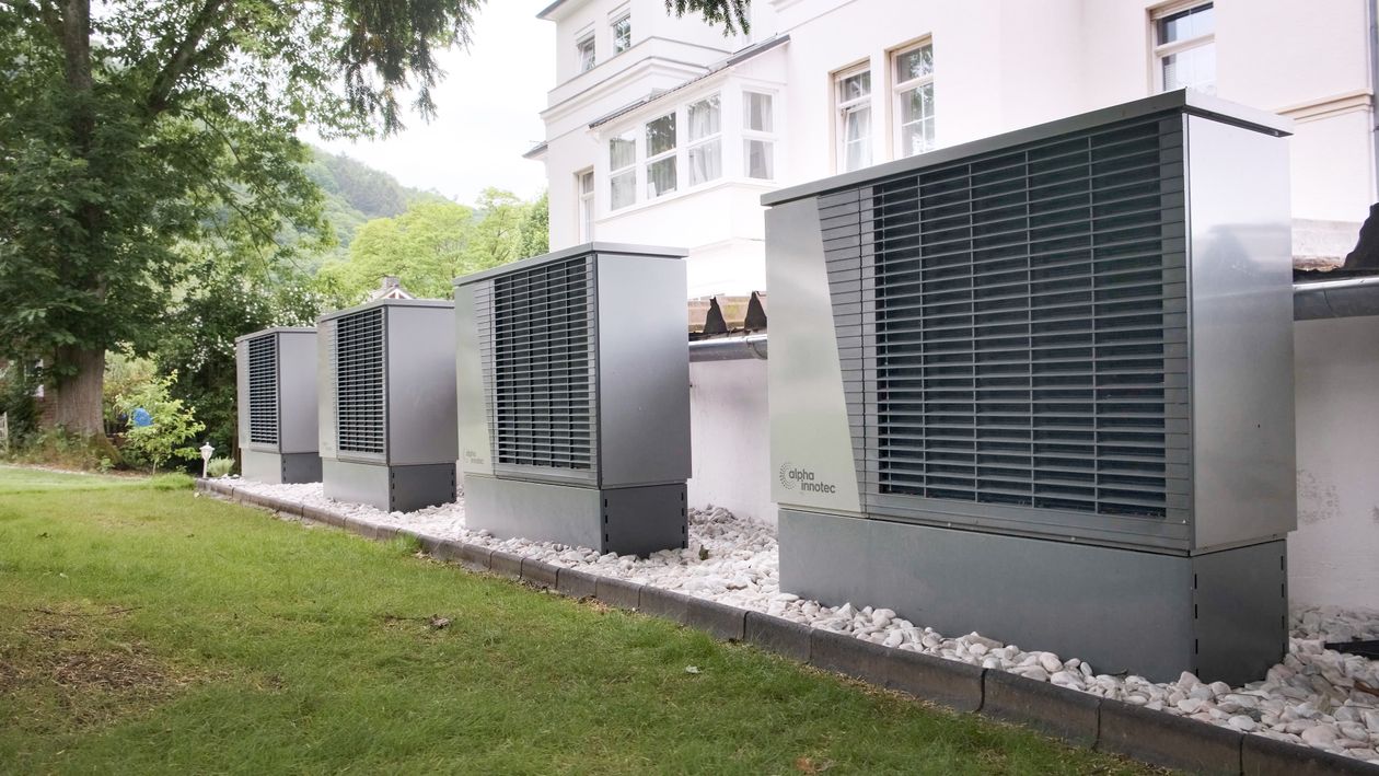 Rij warmtepompen buiten een gebouw als symbool voor duurzame energie