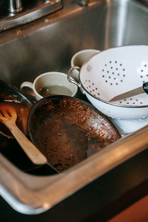 Berg vuile pannen en afwas in een verstopte gootsteen na het koken