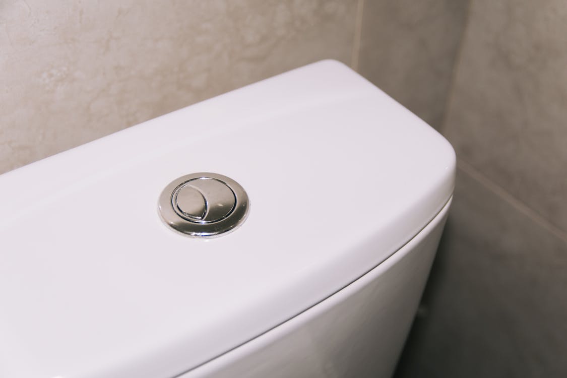 Close-up van een modern wc-pot met chroom spoelknop