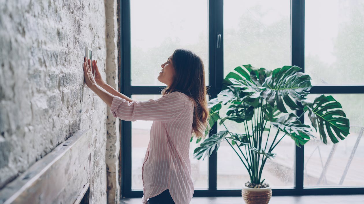 Vrouw bedient het thermostaat in een woonkamer