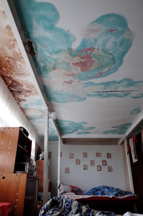 Bruine vochtvlek op een wit plafond door waterlekkage